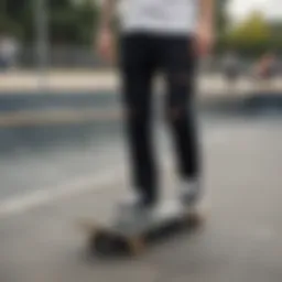 A skateboarder rocking black ripped pants at a skate park
