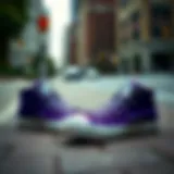 A pair of vibrant purple Converse shoes on a city sidewalk.