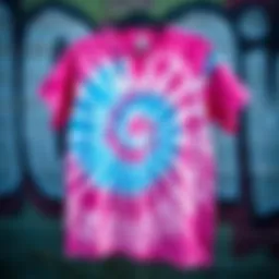 A vibrant pink and blue tie dye shirt displayed against a graffiti wall