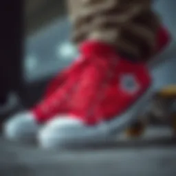 A close-up of red and black Converse shoes against a skateboard